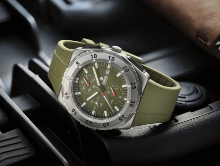 CONTÉVANOU military style analog wristwatch with green dial and olive strap, placed on black surface.