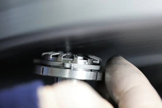 CONTÉVANOU precision watch part held by gloved hand, mechanical horology focus