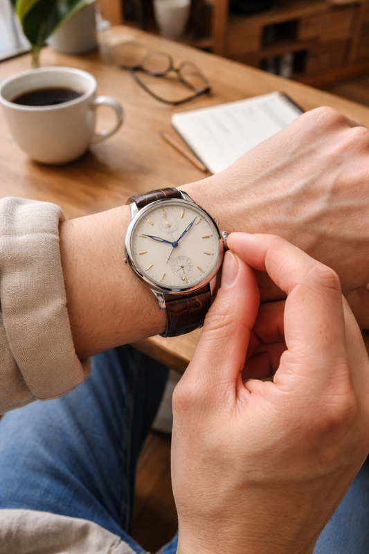 CONTÉVANOU classic mechanical wristwatch with brown leather strap being adjusted