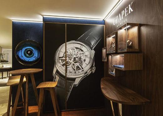 Contévanou Czapek Genève watch boutique interior with wooden tables, stools, and illuminated watch displays