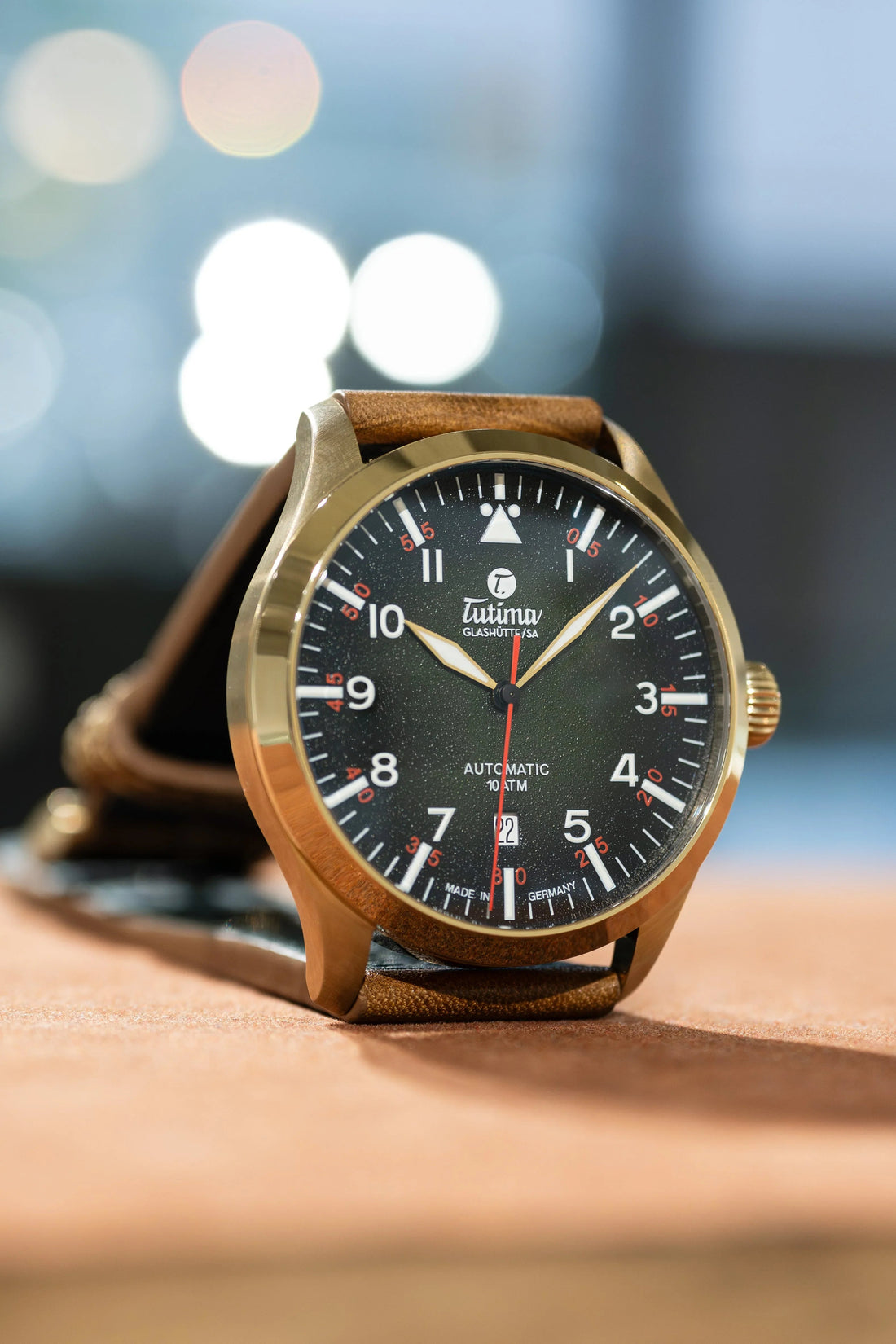 Tutima Glashütte automatic wristwatch with black dial, bronze case, brown leather strap, and date display