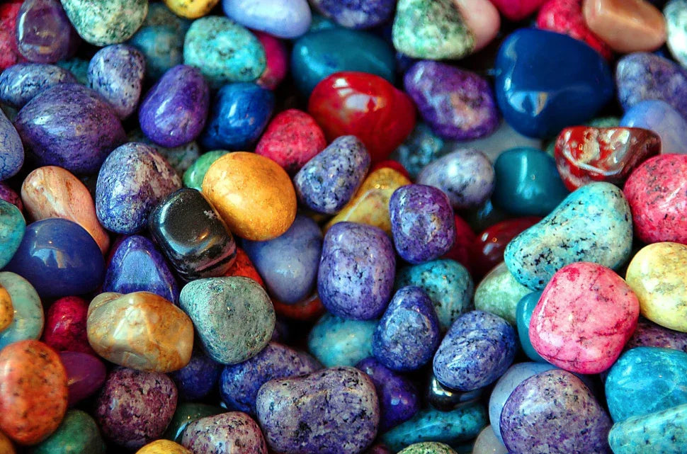 Colorful polished aventurine stones in various shades of blue, purple, red, and green, showcasing vibrant jewelry materials