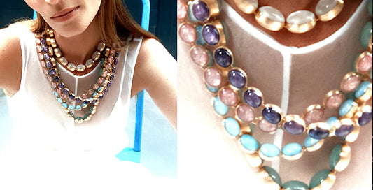 Woman wearing multiple colorful gemstone necklaces with gold settings over a white sleeveless top, showcasing luxury jewelry by CONTÉVANOU
