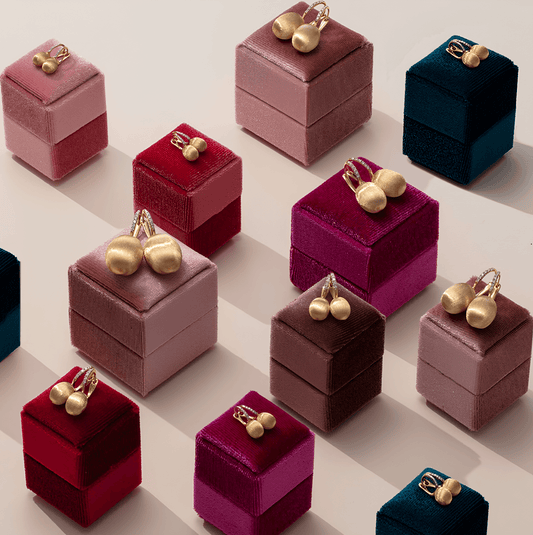 CONTÉVANOU gold earrings displayed on velvet boxes in various colors, jewelry collection