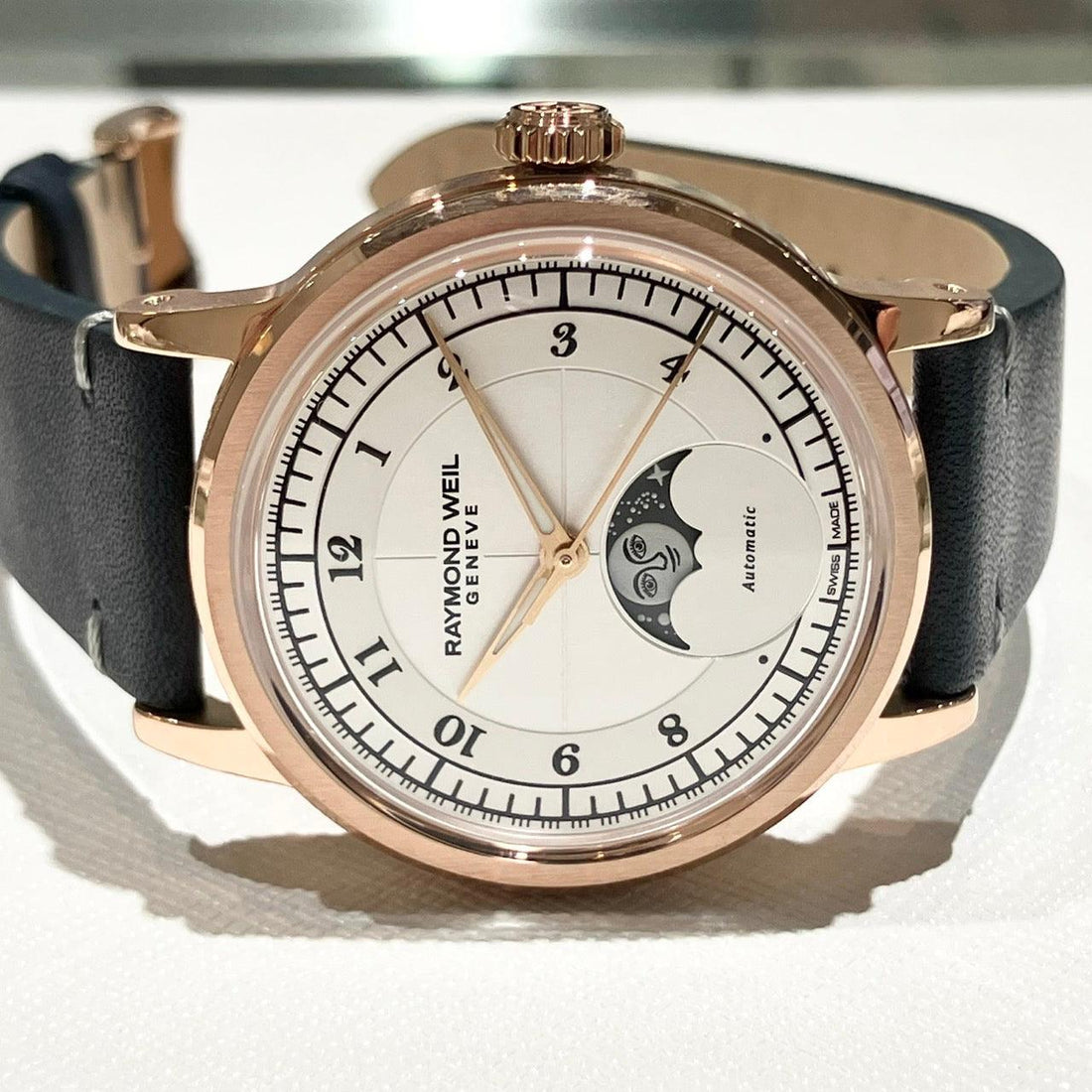 Raymond Weil Genève automatic wristwatch with moon phase display, rose gold case, and black leather strap