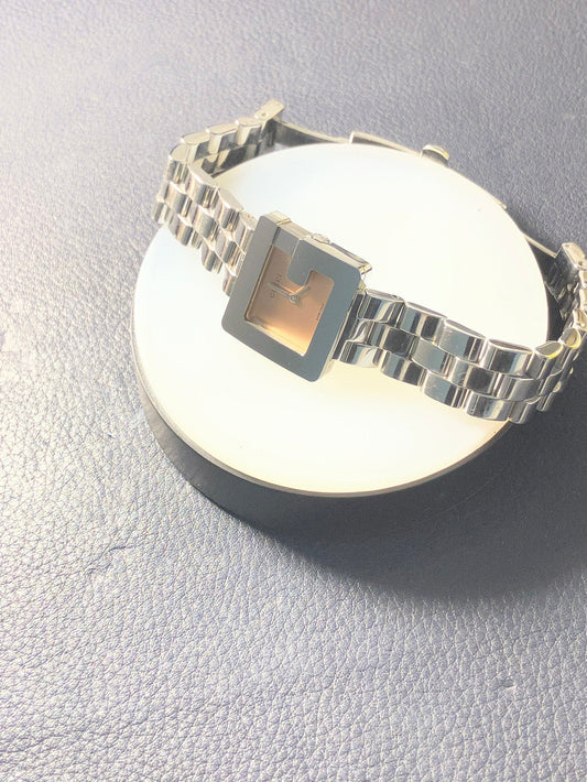 CONTÉVANOU square-faced silver wristwatch with metal link band on dark textured surface