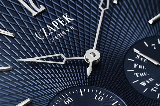 Close-up of a blue Czapek Genève mechanical watch face with textured dial and silver hands