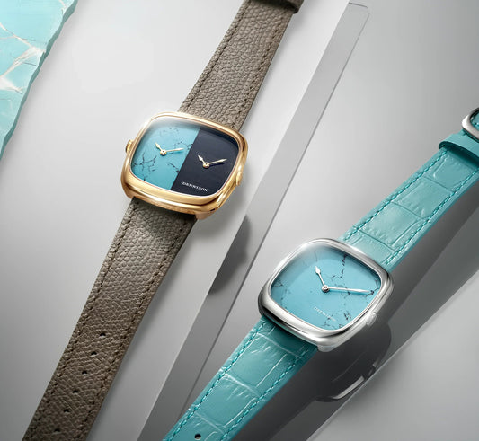ターコイズ文字盤のレディース腕時計2本。ゴールドとシルバーのケース、革ベルト。
