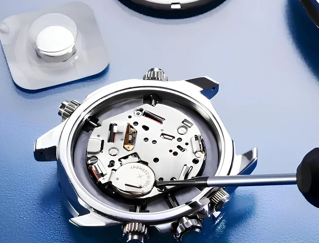 Close-up of a watch battery replacement inside a silver chronograph case with precision screwdriver