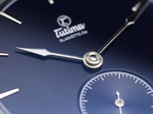 Close-up of a Tutima Glashütte wristwatch with silver hands and a blue dial, showcasing elegant watchmaking